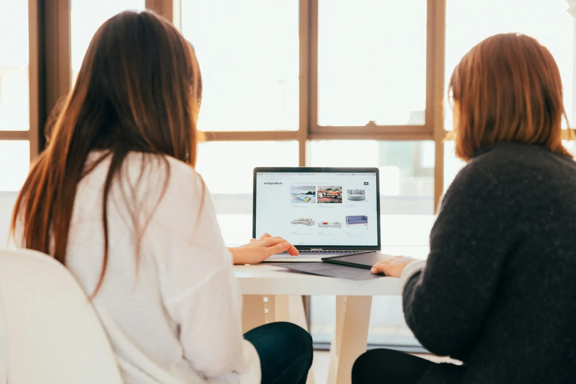 Two business owners planning finances together at a workshop table
