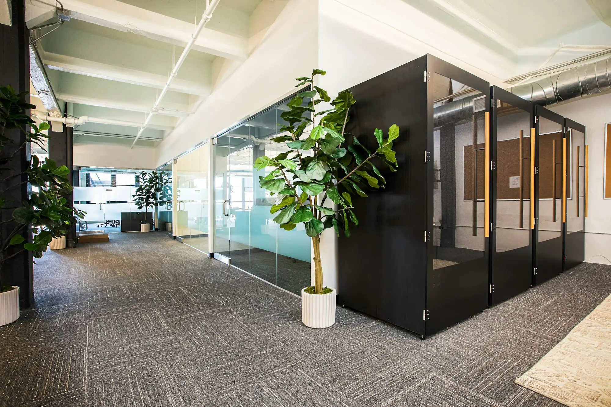 Empty open-plan office with glass meeting rooms where a company's director and lender might sign finance paperwork